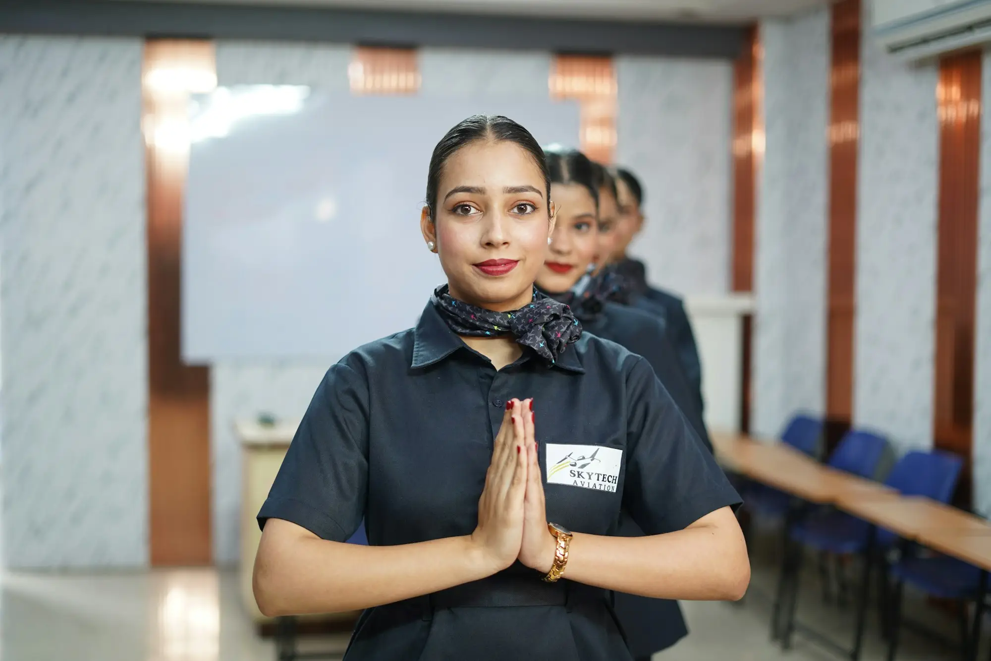 A member of school staff greeting with folded hands